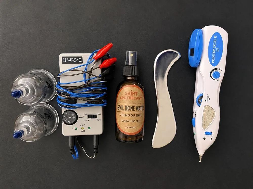Cups, an electro-stimulation unit, a gua sha tool and herbal liniment